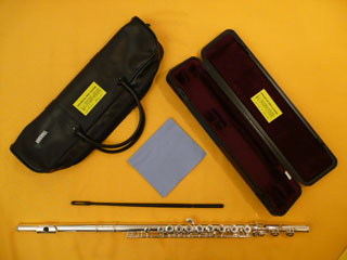Photo de flûte  traversière Yamaha 281 et ses accessoires : étui rigide, housse, chamoisine et écouvillon