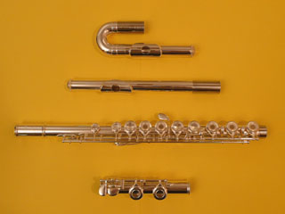 Photo de flûte  traversière Yamaha 281 démontée avec ses deux têtes : droite et courbe. 